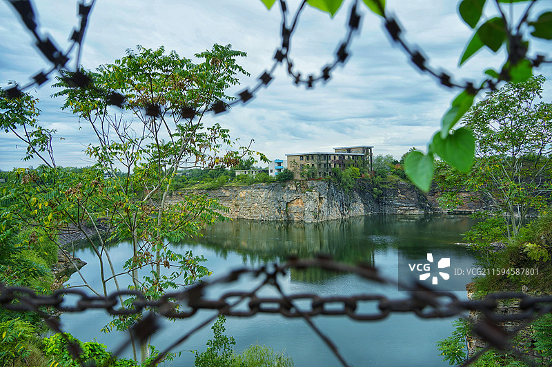 安徽省亳州市涡阳县龙山镇龙山池塘铁丝网和悬崖上废弃的学校建筑遗迹旧址图片素材