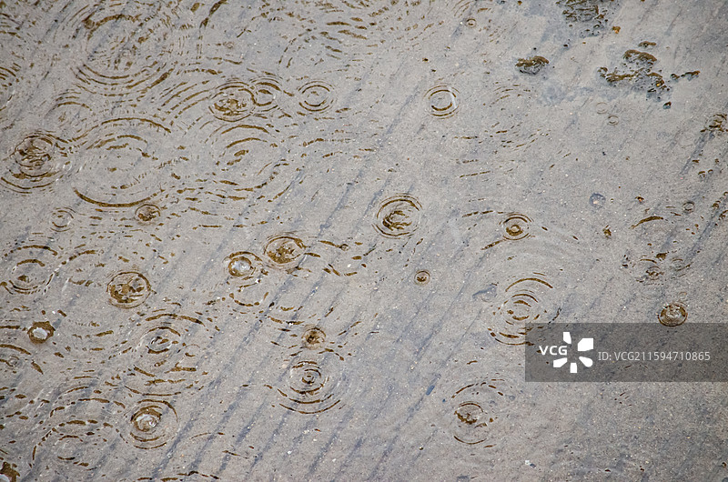 中国自然天气气候拍摄主题，下雨天雨水落在水泥地地面上溅起大量的水花，户外白昼无人图像摄影图片素材