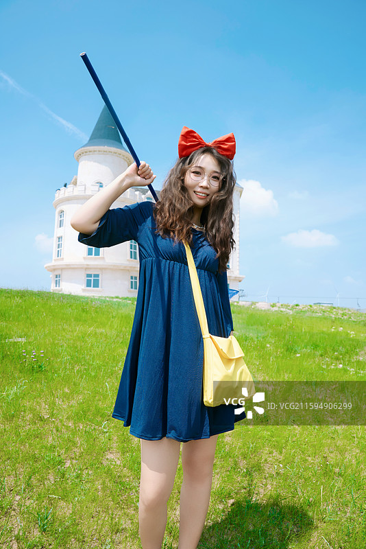 身穿小魔女服饰在城堡前拍照打卡的亚洲美女图片素材