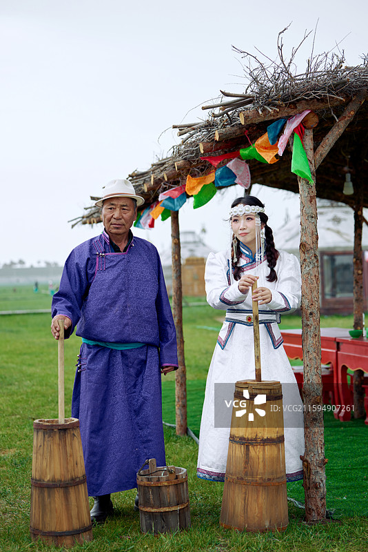 在蒙古包前为游客打奶茶的蒙古族父女图片素材