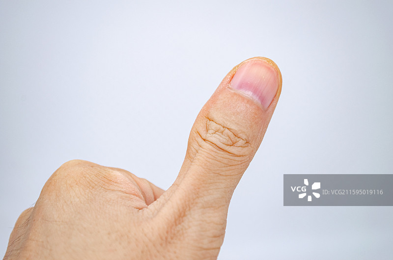 中国人体特征拍摄主题，黄种人的手部姿势动作特写，一根人竖起大拇指赞美认可的手势特写，室内图像摄影图片素材