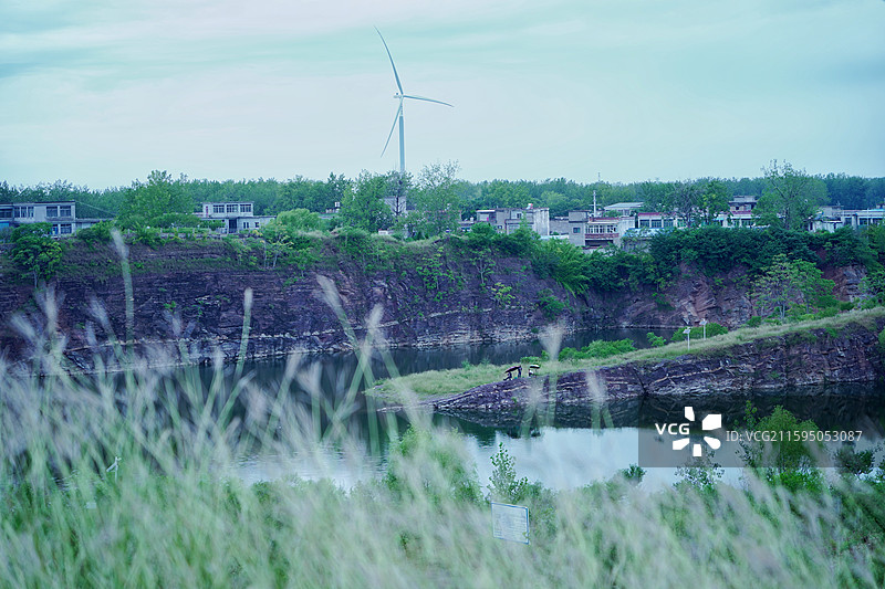 安徽省亳州市涡阳县龙山镇龙山池塘田野村庄和发电风车图片素材