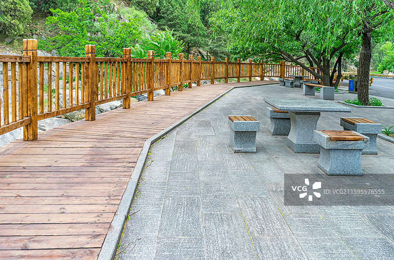 中国自然风光拍摄主题，山东省泰安市岱岳区彩石溪风景区，绿色的山区树林，岩石组合排列的石椅和石桌图片素材