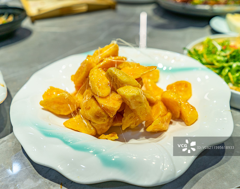 中国餐饮行业饮食产业，传统经典中国食品，一盘子拔丝地瓜拔丝山药，室内无人图像图片素材