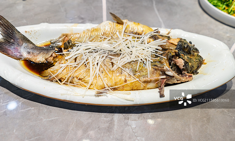 中国餐饮行业饮食产业，传统经典中国食品，一盘子清蒸鲈鱼清江鱼鲤鱼浇上热油葱丝，室内无人图像图片素材