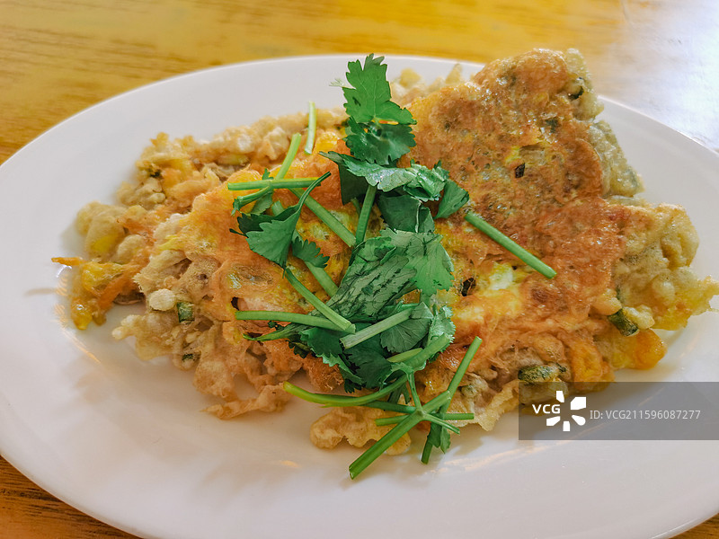 潮州古城潮汕美食蚝烙餐桌上盘子里的食物的高角度视图图片素材