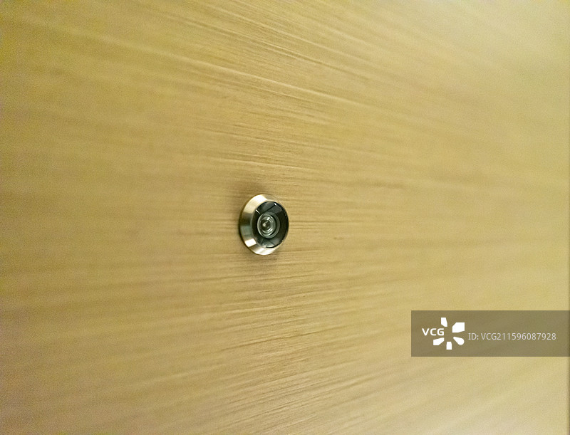中国酒店宾馆民宿招待所住宿拍摄主题，黄色木门上查看访客的猫眼设备，室内人的手图像摄影图片素材