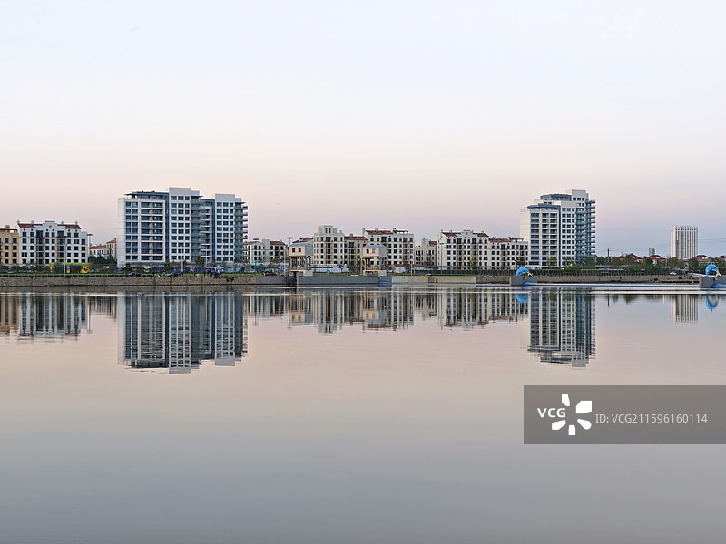 傍晚的北戴河大蒲河如镜子版平静，倒映着阿那亚北岸三期的建筑图片素材