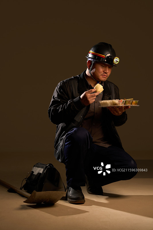 一名煤矿工人吃盒饭图片素材