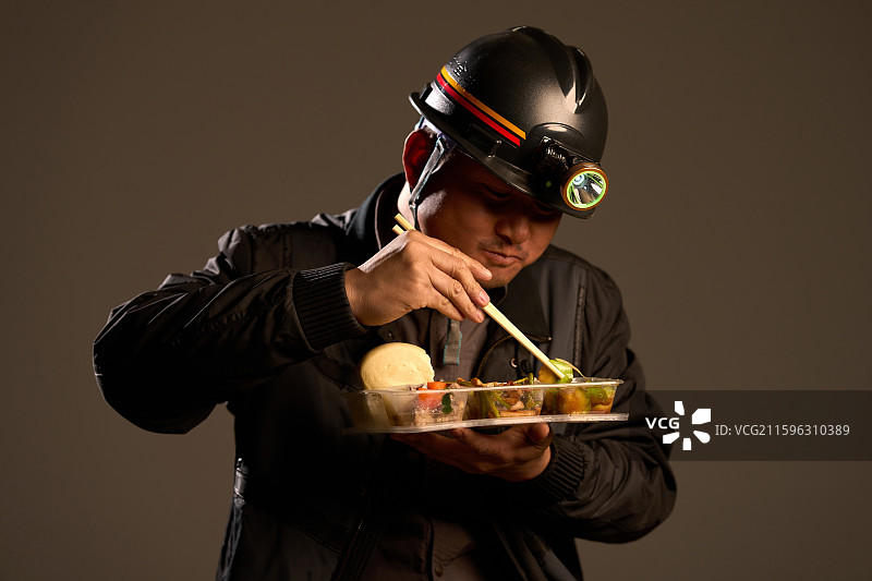 一名煤矿工人吃盒饭图片素材
