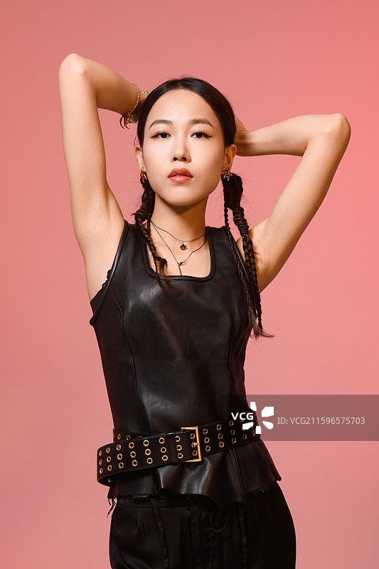 粉红色背景下梳着辫子的时尚美女肖像图片素材