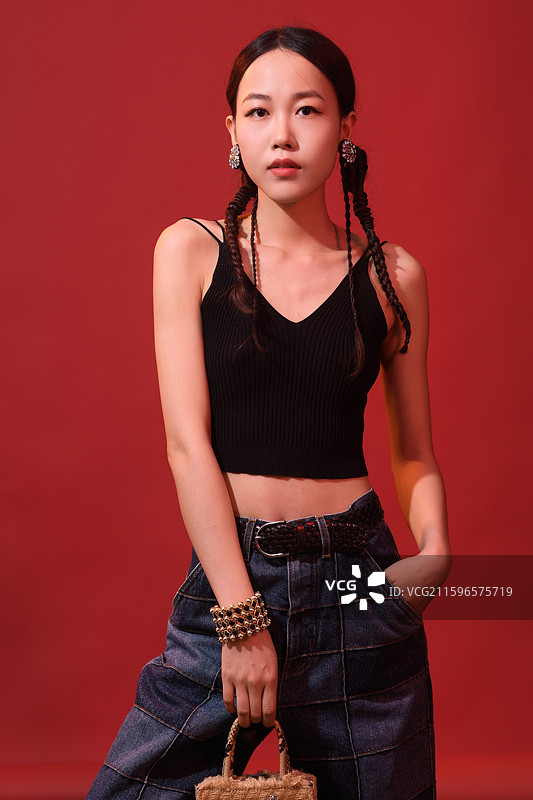 在红色背景下的年轻女子时尚肖像图片素材