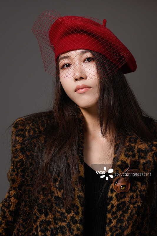 戴帽子穿豹纹大衣的年轻女子特写肖像图片素材