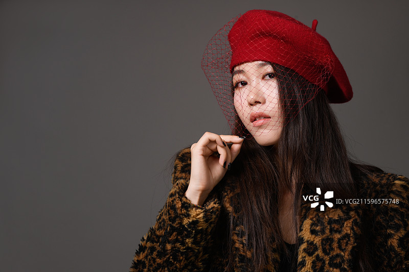 戴帽子穿豹纹大衣的年轻女子特写肖像图片素材
