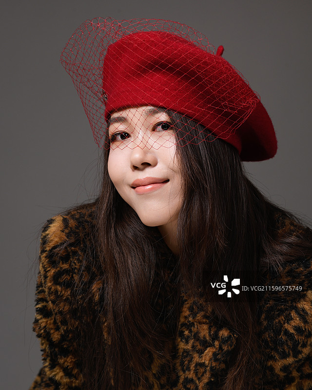 戴帽子穿豹纹大衣的年轻女子特写肖像图片素材