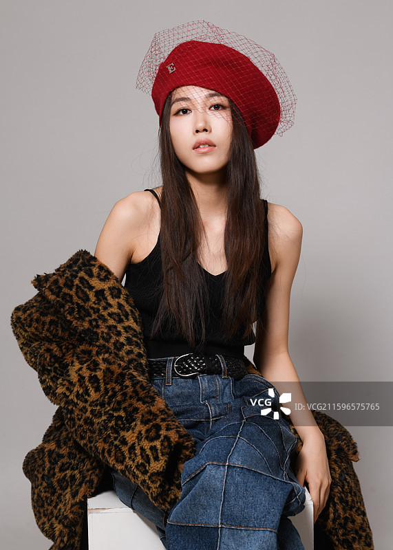 戴帽子坐着的年轻女子影棚肖像图片素材
