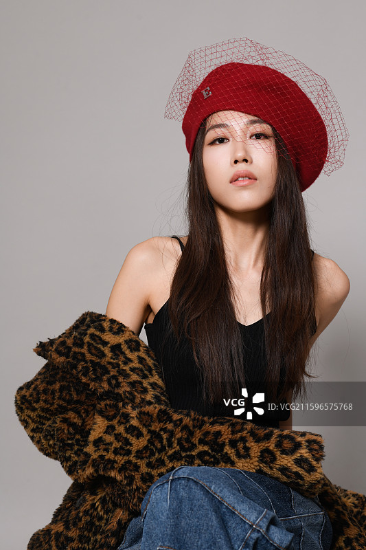 戴帽子坐着的年轻女子影棚特写肖像图片素材