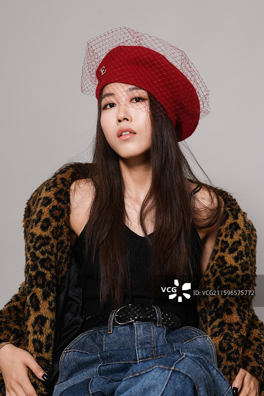 戴帽子坐着的年轻女子影棚特写肖像图片素材