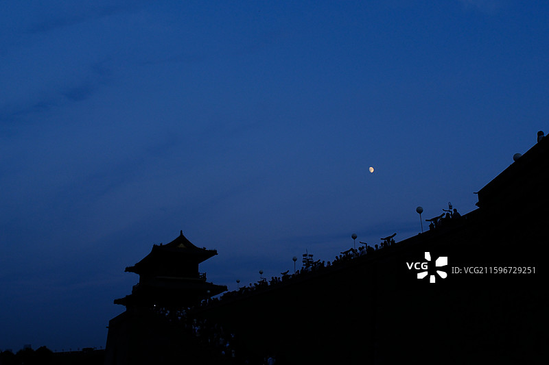 傍晚黄昏夜晚蓝色天空月牙月亮月色月夜。正定古城墙城门楼。树梢。自然风光背景图图片素材