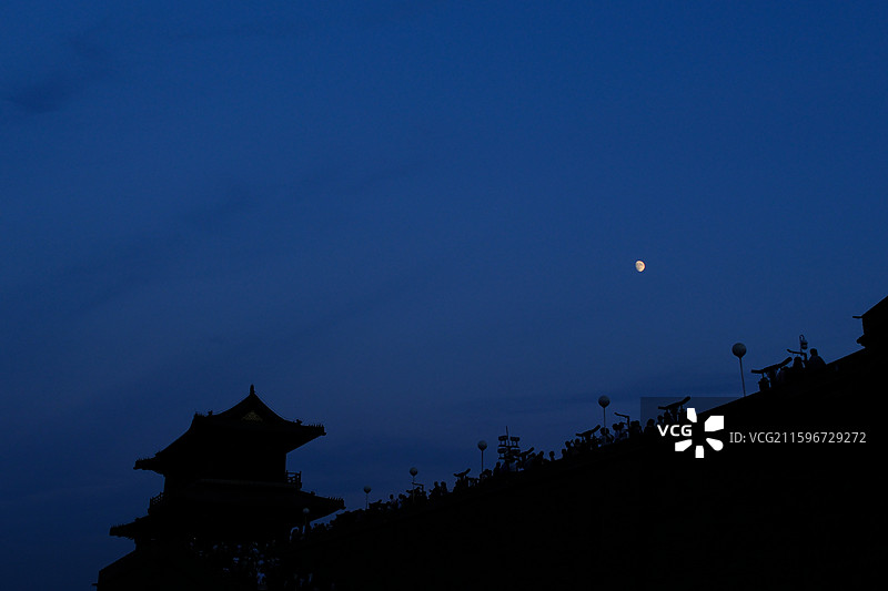 傍晚黄昏夜晚蓝色天空月牙月亮月色月夜。正定古城墙城门楼。树梢。自然风光背景图图片素材