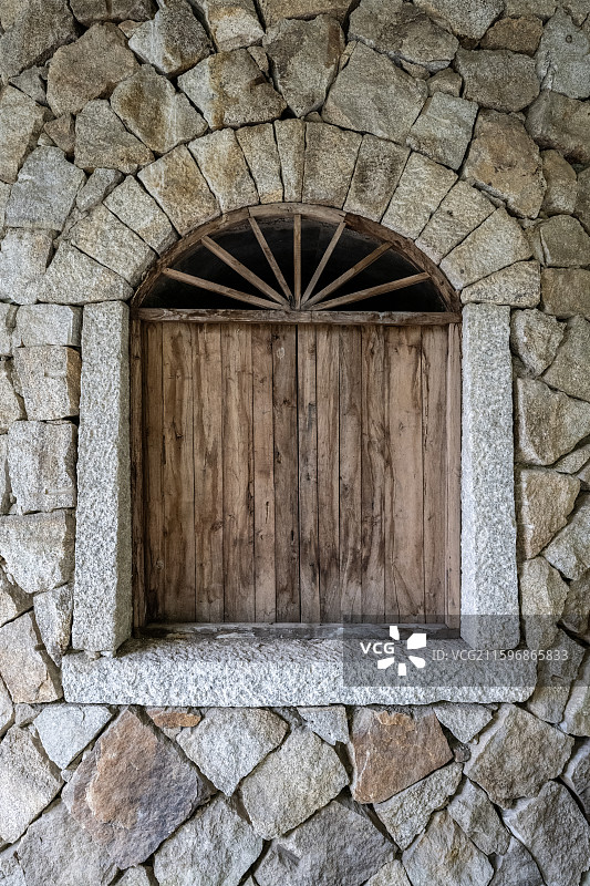 石头垒砌磊起的房子装着木头做的窗子图片素材