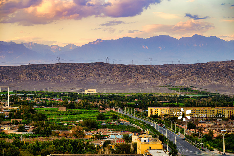 新疆吐鲁番市晚霞，日暮时分，从市区北望雄伟的博格达山。图片素材