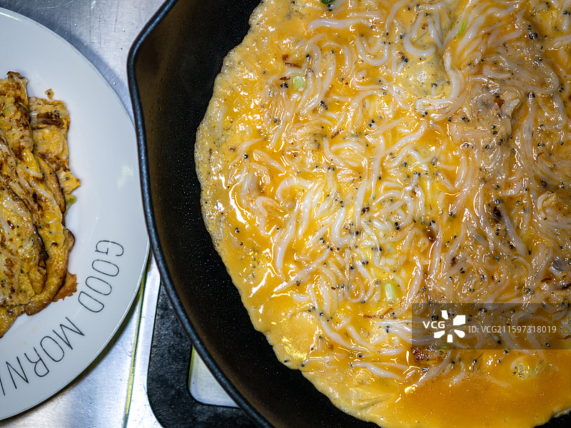 平底锅中煎制的银鱼蛋饼图片素材