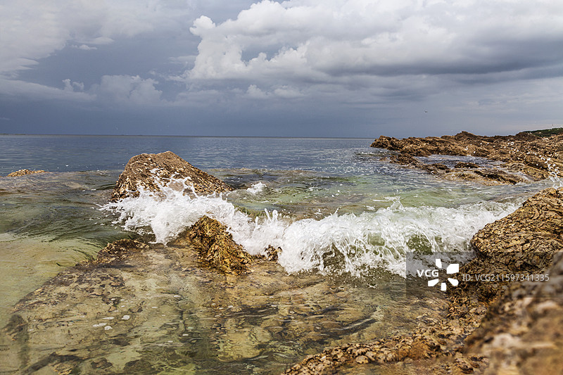 山东省烟台市牟平区养马岛果冻海景区 海浪冲击岸边礁石的照片图片素材