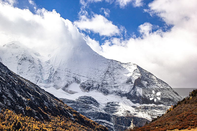 四川甘孜稻城亚丁 被云遮挡的神山雪山央迈勇图片素材