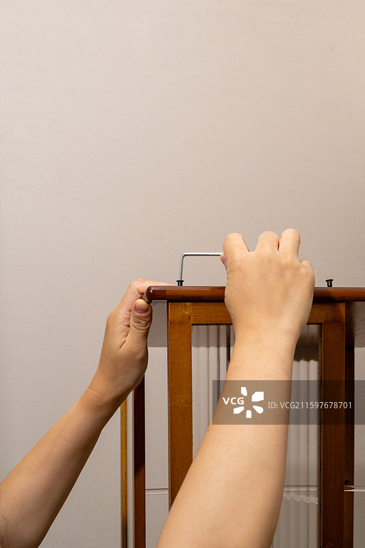 双手握住木制床栏的特写图片素材