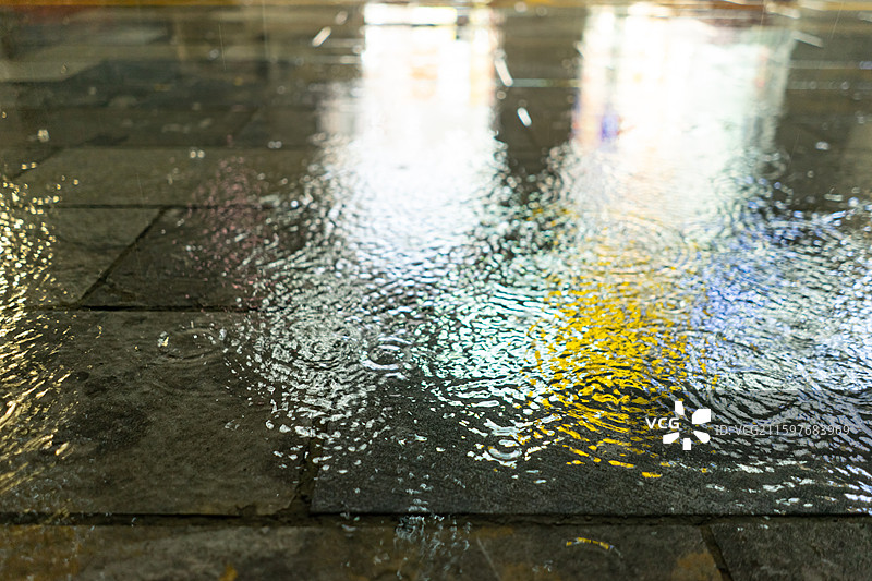 中国自然天气气候拍摄主题，下雨天马路公路街道雨水落在水泥地地面上溅起大量的水花，户外夜晚无人图像摄影图片素材