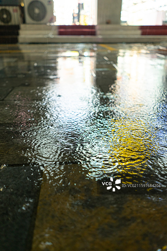 中国自然天气气候拍摄主题，下雨天马路公路街道雨水落在水泥地地面上溅起大量的水花，户外夜晚无人图像摄影图片素材