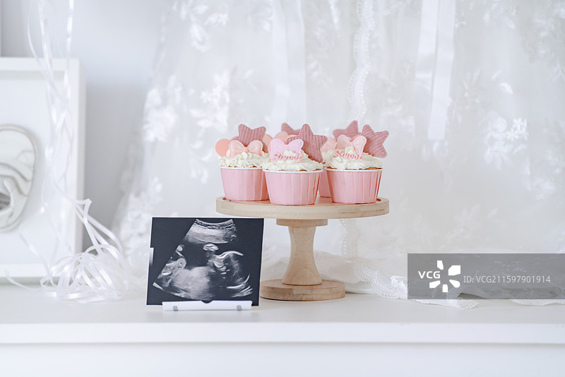 温馨的粉红色花式冰激凌蛋糕与女婴胎照图片素材