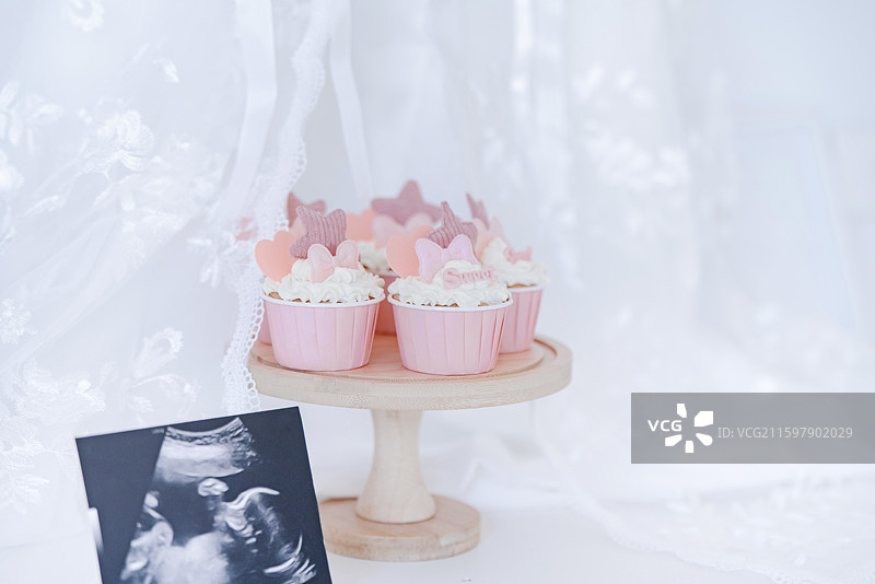 温馨的粉红色花式冰激凌蛋糕与女婴胎照图片素材