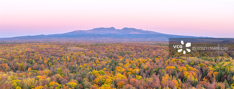 秋天航拍吉林长白山五彩森林和远处的天池山峰落日秋景风光图片素材