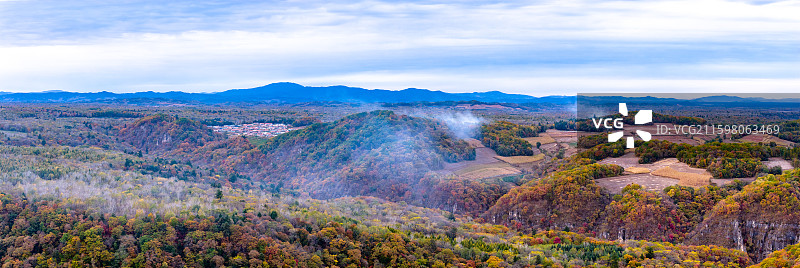 秋天航拍傍晚吉林抚松县森林和村庄升起的炊烟袅袅图片素材