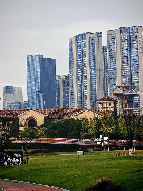城市与自然 草地如茵复古建筑与彩色廊桥点缀其间，现代高楼观景塔。新旧建筑共生。自然绿意与城市轮廓交融图片素材