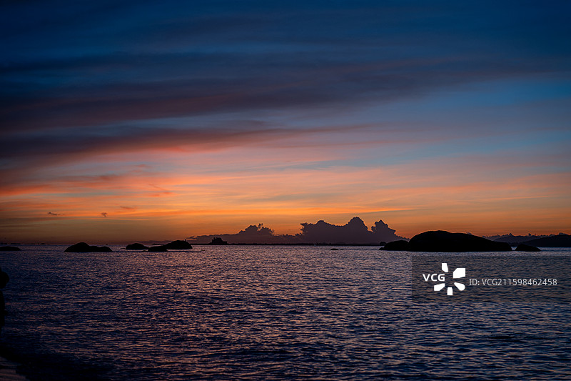 厦门黄厝海滩日出朝霞火烧云海边日落岩石点缀天空云彩海面平静浪漫构图图片素材