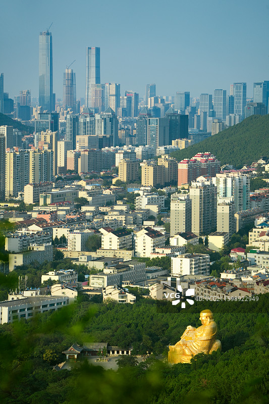 千佛山弥勒大佛与城市建筑的合影图片素材