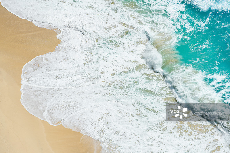 鸟瞰绿松石般的海水冲向沙滩图片素材