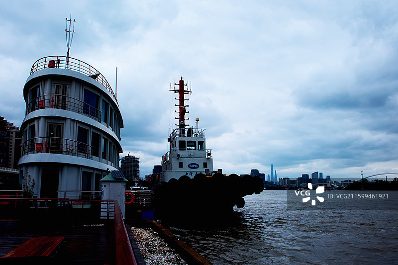 江湾船影：工业船舶与都市天际的烟雨对话图片素材