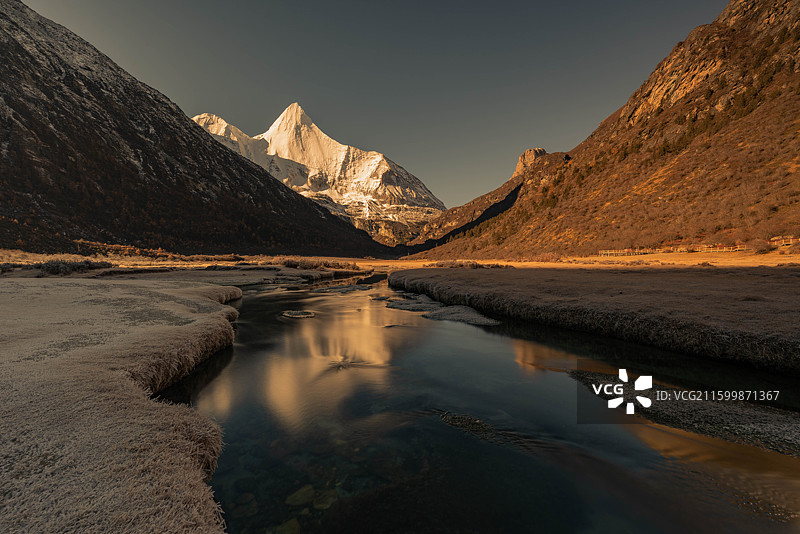 清晨霜冻的洛绒牛场远望央迈勇雪山图片素材