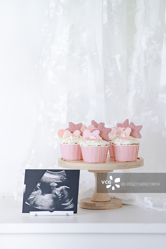 温馨的粉红色花式冰激凌蛋糕与女婴胎照图片素材