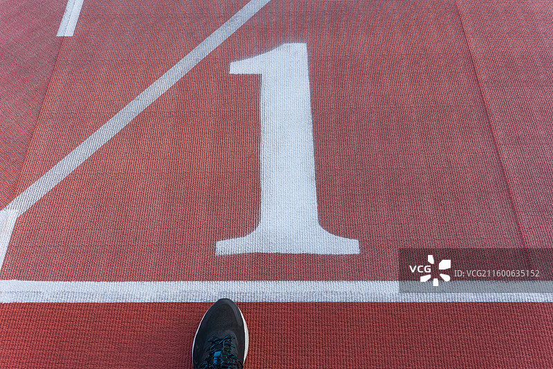 一只脚踏上红色跑道起跑线特写图片素材