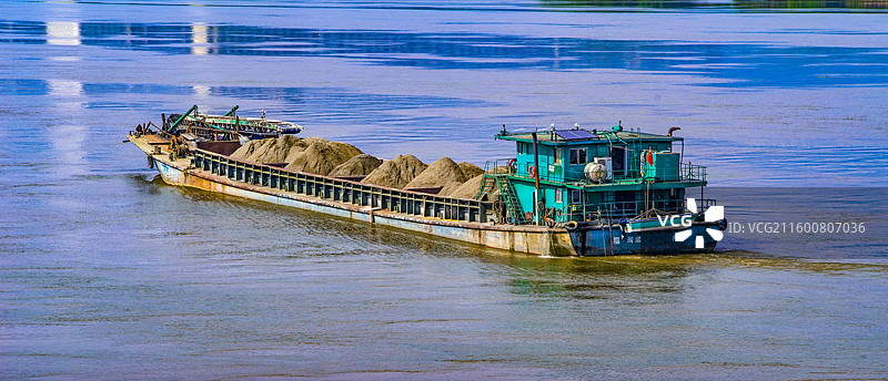 福州乌龙江雨雾弥漫中满载石沙安稳行驶在闽江江面上的运沙船图片素材