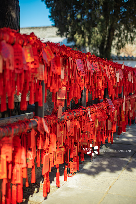 中国传统文化和自然风光拍摄主题  ,铁栏杆子上悬挂着大量红色许愿牌子，户外白昼无人图像摄影图片素材