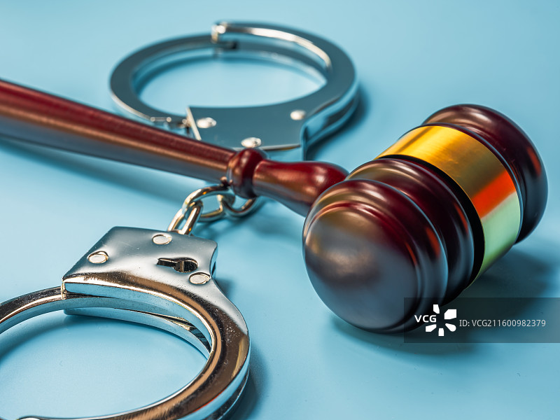 法槌、金属手铐与蓝色背景图片素材