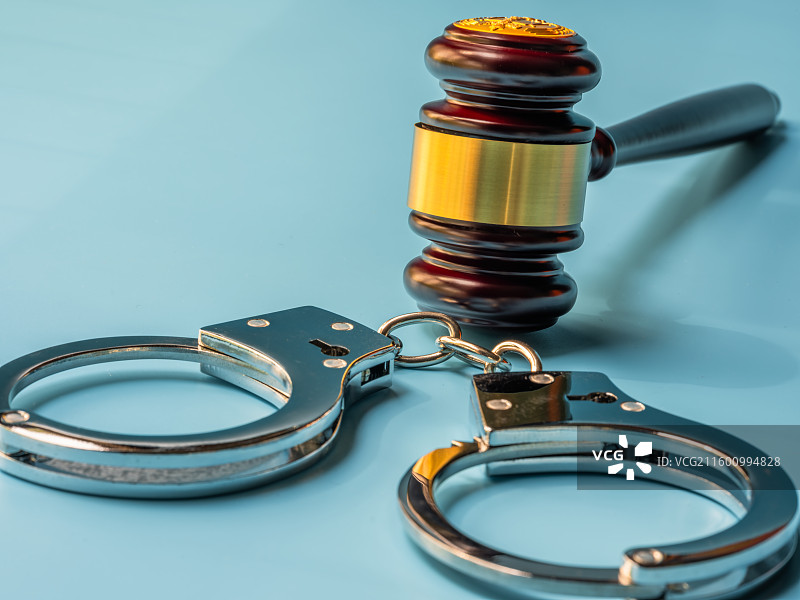 法槌、金属手铐与蓝色背景图片素材