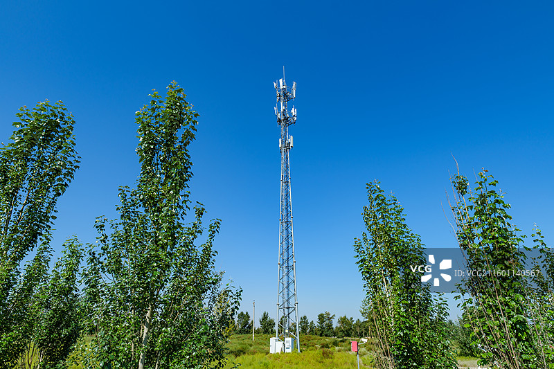 蓝天绿树中的通信铁塔图片素材