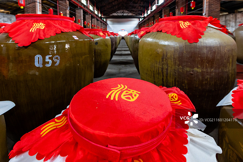 白酒酒厂展示中的窑藏存放于仓库的大酒坛图片素材